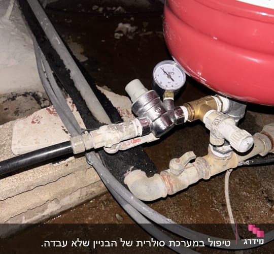 מד לחץ וצינורות מחוברים למיכל אדום
